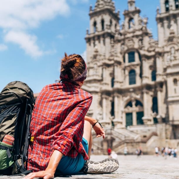 Eine Wanderin vor einer historischen Kirche