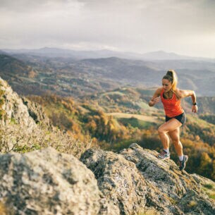Eine laufende Frau auf einem Pfad im Gebirge