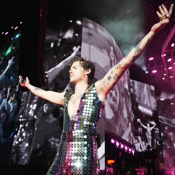 Sänger Harry Styles in einem glitzernden Paillettenanzug auf einer Bühne