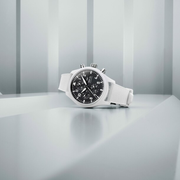 Weiße Uhr mit schwarzem Ziffernblatt vor weißem Hintergrund