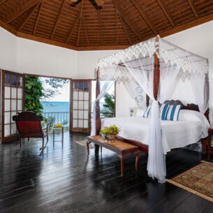 Luxuriöse Hotelsuite im Kolonialstil mit Holzmöbeln und Meerblick
