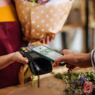 Kontaktlose Zahlung mit American Express Kreditkarte per Smartphone in einer Boutique