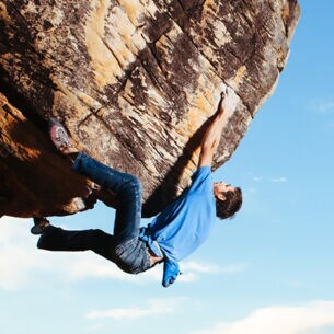 Eine Person hängt an einer Felswand ohne Sicherung