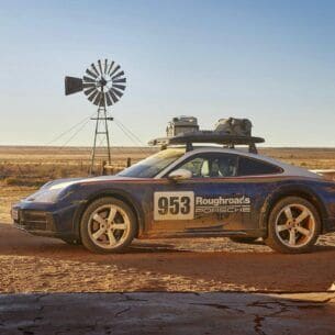 Porsche 911 Dakar im Rallye-Design in der Seitenansicht vor einer Wüstenlandschaft