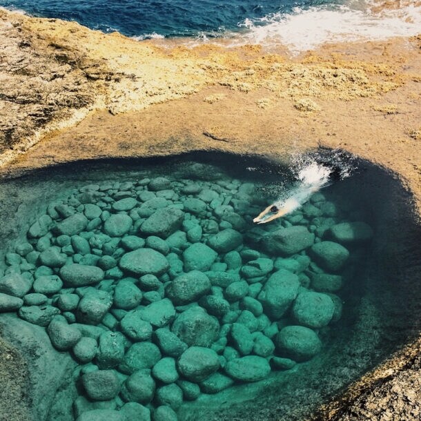 Luftaufnahme einer Person, die in eine Bucht eintaucht