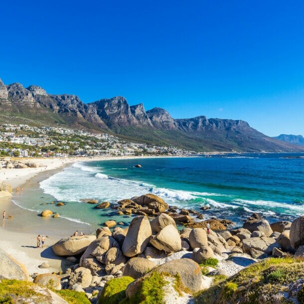 Felsige Strandbucht bei Kapstadt mit Gebirgskette im Hintergrund