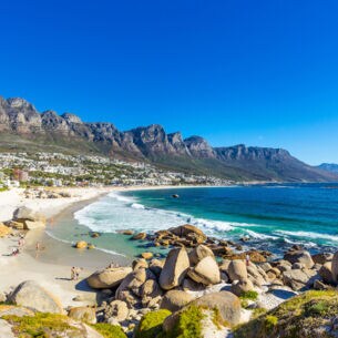 Felsige Strandbucht bei Kapstadt mit Gebirgskette im Hintergrund