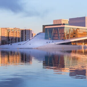 Weißes futuristisches Opernhaus mit Glasfassade am Wasser in Oslo