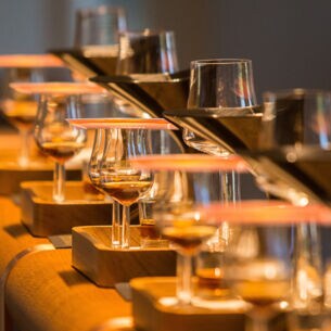 Mit Hennessy gefüllte Cognac-Gläser auf einem abgerundeten Holztresen