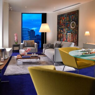 Eine moderne, farbenfroh eingerichtete Hotelsuite mit Stadtblick