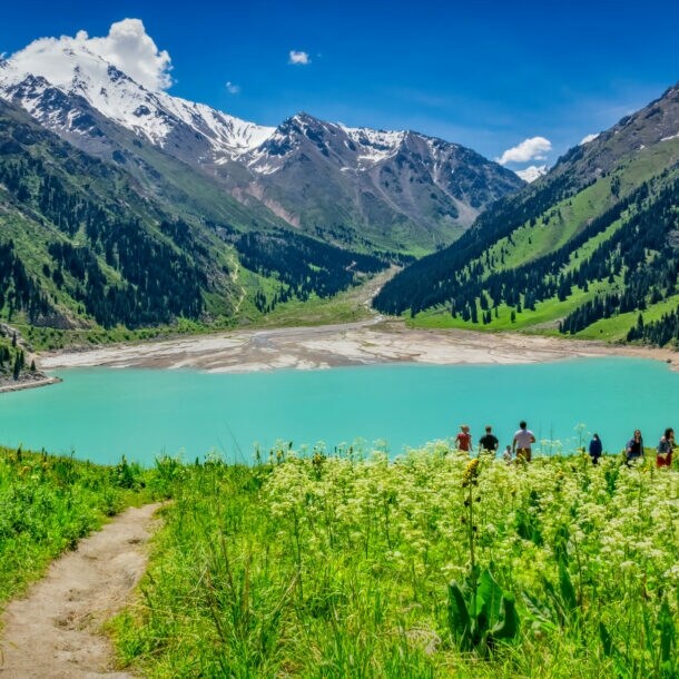 Blick auf den Almaty See in Kasachstan, der in ein Gebirge gebettet ist.