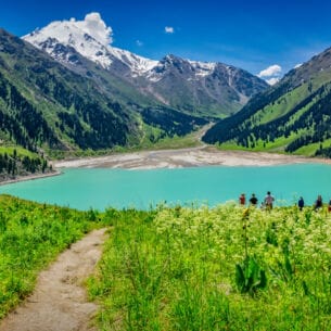 Blick auf den Almaty See in Kasachstan, der in ein Gebirge gebettet ist.
