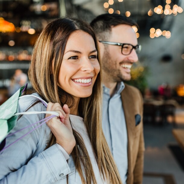 Nahaufnahme eines lachenden Paares mit Einkaufstüten in einem Restaurant