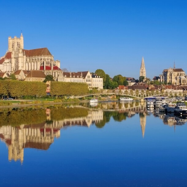 Stadtpanorma von Auxerre mit Kathedrale und Abtei, davor Boote auf einem Fluss