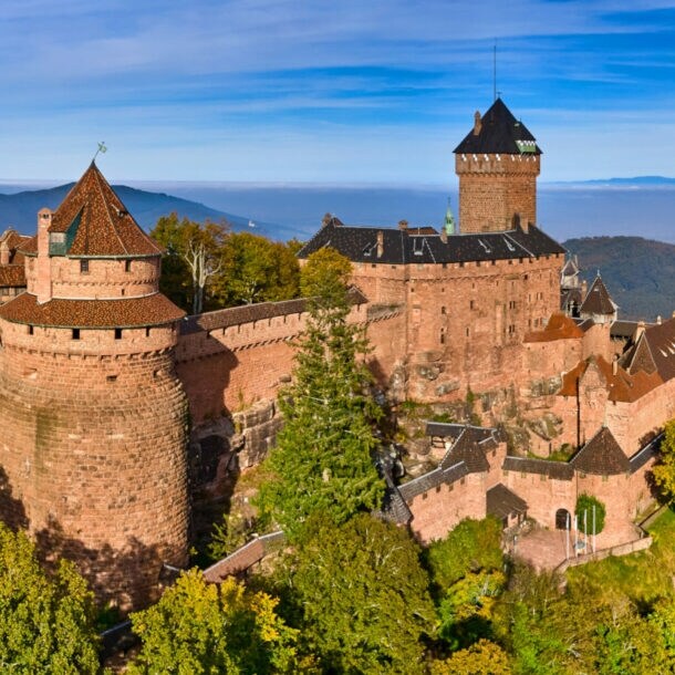Panoramaaufnahme der mittelalterlichen Hohkönigsburg auf einem bewaldeten Hügel im Elsass
