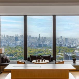 Hotelsuite im japanischen Stil mit Blick durch ein bodentiefes Panoramafenster auf die Skyline von Tokio
