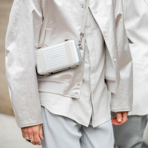 Models ins heller Businesskleidung tragen eine von Dior und Rimowa entwickelte Tasche