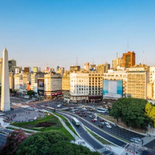 Weißer Obelisk auf einer großen Straßenkreuzung im Stadtzentrum von Buenos Aires bei Sonnenuntergang
