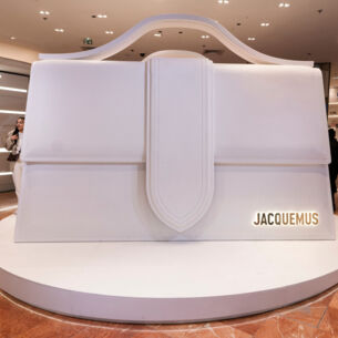 Alt-Text: Eine weiße, überdimensionale Le Bambino-Tasche des Designers Jacquemus in der Pariser Galeries Lafayette.
