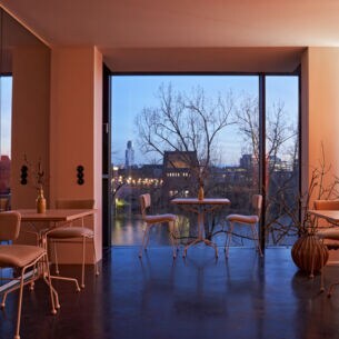 Innenraum eines modernen Restaurants mit bodentiefen Fenstern und Panoramablick auf den Main in Frankfurt