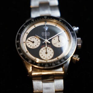 Nahaufnahme einer alten Rolex-Uhr, Modell Cosmograph Daytona Oyster mit schwarz-hellgelbem Zifferblatt und Metallarmband