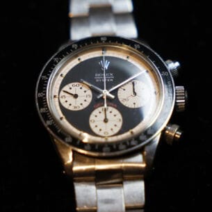 Nahaufnahme einer alten Rolex-Uhr, Modell Cosmograph Daytona Oyster mit schwarz-hellgelbem Zifferblatt und Metallarmband