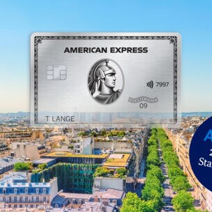 Fotocollage einer silbernen American Express Kreditkarte vor dem Stadtpanorama von Paris mit Eiffelturm.