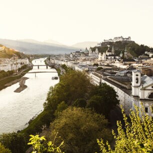 Panorama der Stadt Salzburg mit dem Fluss Salzach in der Abendsonne