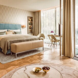 Moderne, helle Hotelsuite mit Parkettboden und bodentiefen Fenstern.