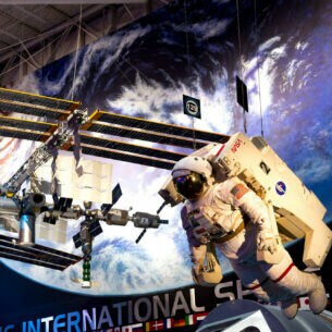 Die International Space Station und ein Astronaut als hängende Modelle in einem Museum.