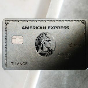 Nahaufnahme einer silberschimmernden American Express Platinum Kreditkarte aus Metall auf einem hellen Marmoruntergrund