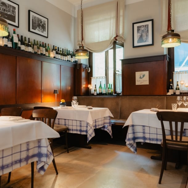 Gemütlicher Speiseraum mit Holzverkleidung und eingedeckten Tischen in einer Brasserie.