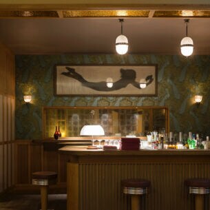 Ein holzverkleideter Tresen in einer modernen Bar mit gedimmter Beleuchtung.
