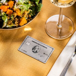 Eine Amex Platinum Card liegt auf einem gedeckten Tisch in einem gehobenen Restaurant