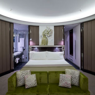 Eine moderne Hotelsuite mit runden Wänden und Doppelbett.