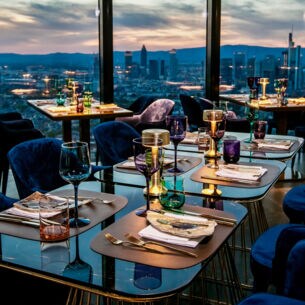 Räumlichkeiten des Restaurant Franziska mit der Skyline Frankfurts im Hintergrund.