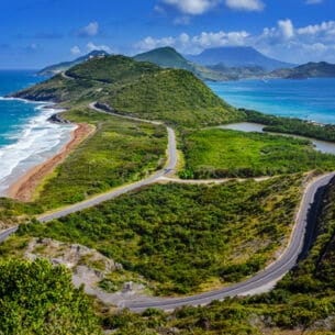 Aufnahme über die Landschaft und Küste der Insel St. Kitts mit der Insel Nevis im Hintergrund.