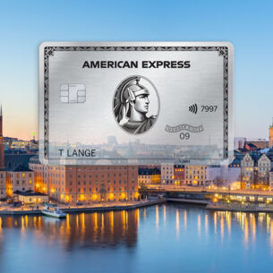 Freisteller einer Platinum Card von American Express vor der abendlich erleuchteten Skyline von Stockholm.