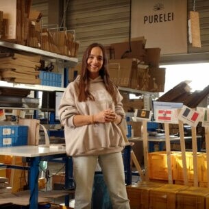 Alisa Jahnke, Co-Founderin von PURELEI steht in einem Lagerraum.