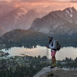 Florian Astor genießt die Aussicht oberhalb eines Bergsees während seiner Wanderung durch Neuseeland.