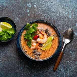 Thai-Suppe Tom Yum mit Meeresfrüchten in einer Keramikschüssel von oben