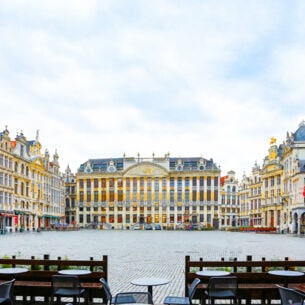 Grand Place in Brüssel mit Tischen und Stühlen im Vordergrund.