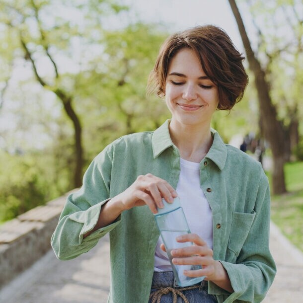Eine junge Frau macht bei schönem Wetter einen Spaziergang in der Mittagspause.