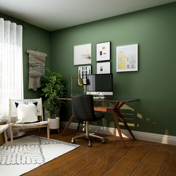 Das Foto zeigt ein geschmackvoll eingerichtetes Home-Office mit grün gestrichenen Wänden.