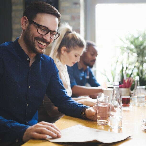Ein junges multikulturelles Team trifft sich zu einem Geschäftsessen.