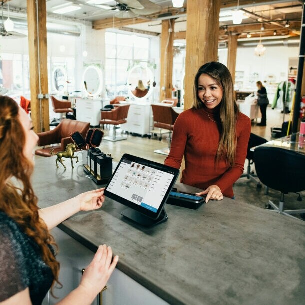 Eine Frau bezahlt im Beautysalon mit Karte.