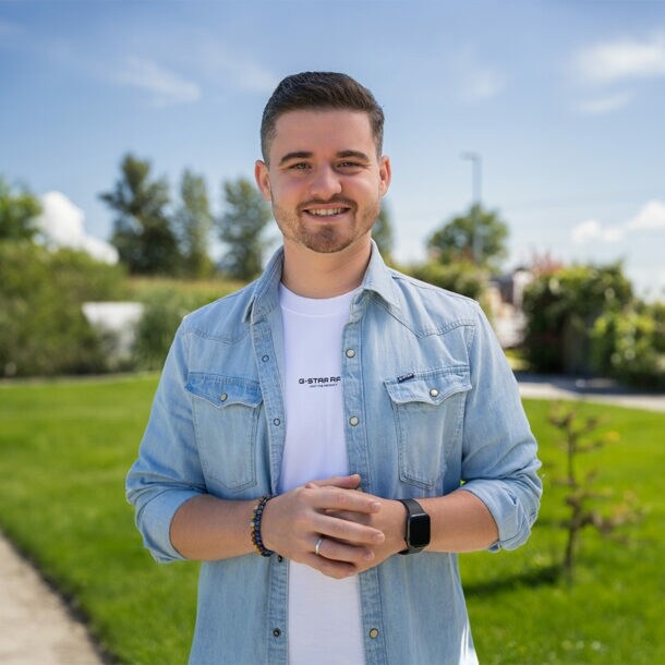 Adstark-Gründer Ruslan Ilyassov steht in einem Park und lächelt in die Kamera.