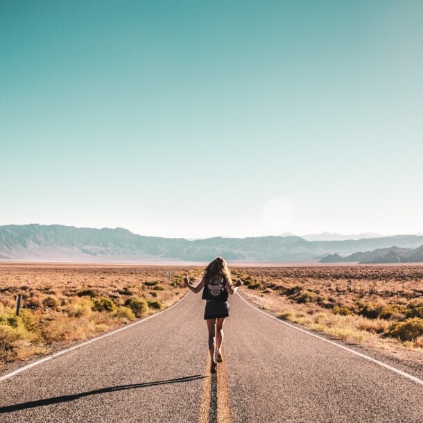 Rückansicht einer Frau, die auf einer Straße in den USA läuft.