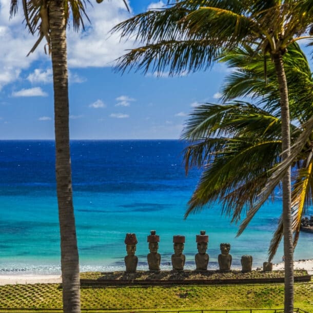 Strand auf der Osterinsel, an dem eine Reihe von Steinfiguren stehen, mit Blick auf den Pazifik.