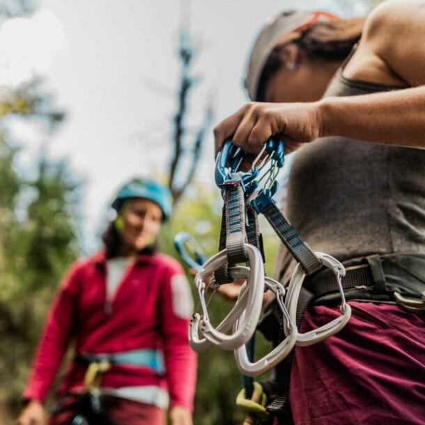 Nahaufnahme von zwei Personen in Kletterausrüstung vor einer Felswand.